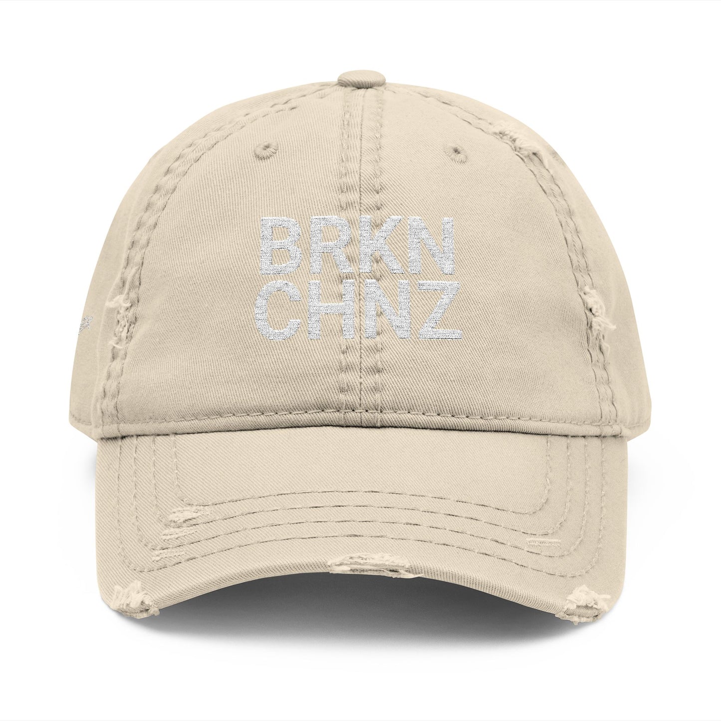 Beige cap with 'BRKN CHNZ' embroidery on a white background