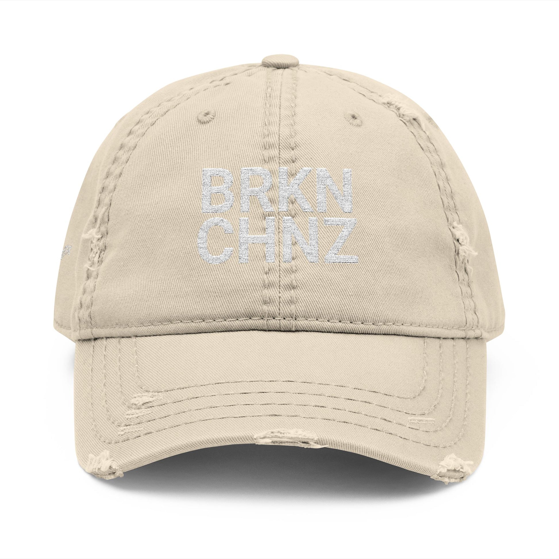 Beige cap with 'BRKN CHNZ' embroidery on a white background